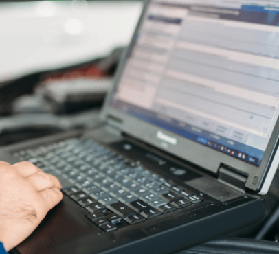 Professional truck service technician performing computer diagnostics on truck